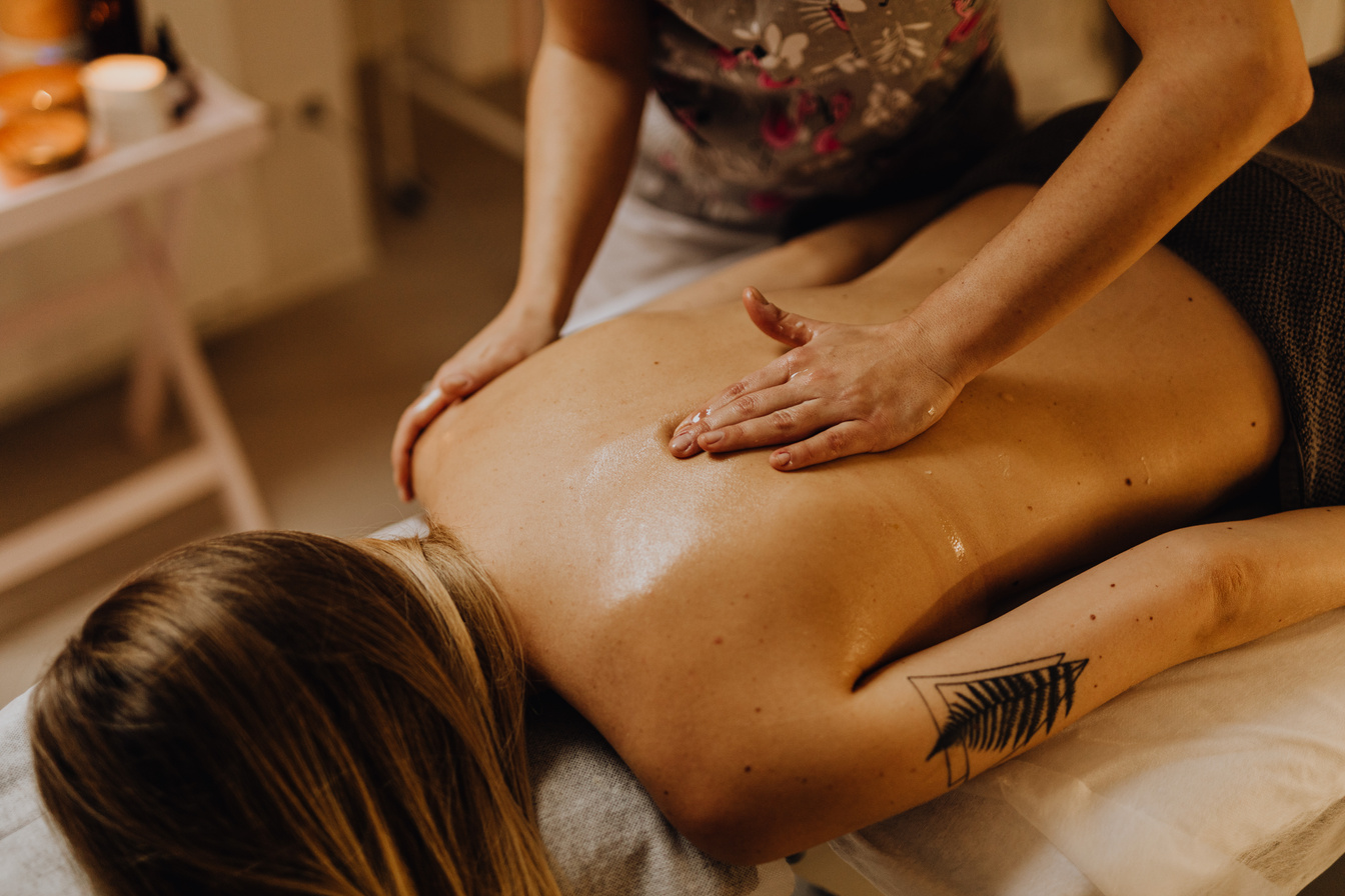 A Tattooed Woman Getting a Back Massage